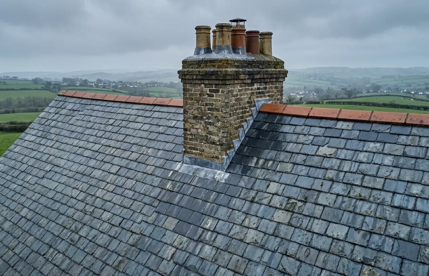 Close aerial crop of a ridge line and chimney stack on a steep roof, photographed from a safe standoff distance